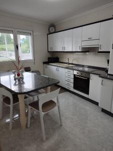 a kitchen with a table and a table and chairs at Apartamento vacacional Meira in Meira