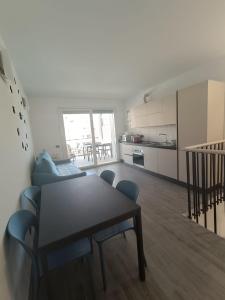 a living room with a table and chairs and a kitchen at laperlablu in Alassio +12 photos
