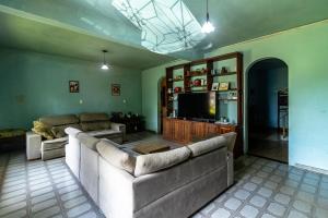 a living room with a large couch and a tv at Welcome to the Amazon in Ananindeua