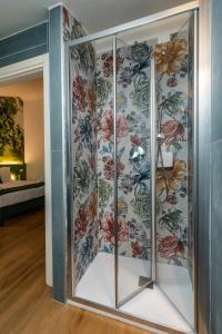 a glass cabinet in a room with a floral wallpaper at Locanda Il Cavallino in Valeggio sul Mincio +65 photos