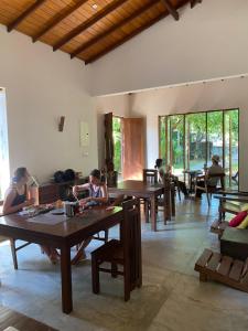 a group of people sitting at tables in a room at Secret House in Dickwella