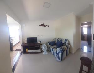a living room with a couch and a tv at Seu Segundo Lar in Valença