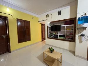 sala de estar con paredes amarillas y TV en Home suite, en Bangalore