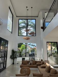 a living room with a couch and some windows at NEW Exclusive Luxury Pool Villa in Mactan Island