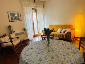 Una sala de estar con una mesa con un jarrón de flores encima. en Tra mare e cultura, en Tarquinia 8 fotos más