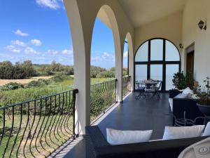 a patio with a table and chairs on a balcony at Les Lauriers, chambre d'hôtes in Siamanna