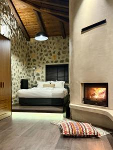 a bedroom with a bed and a fireplace at Bocca al Lupo Villas in Kato Loutraki
