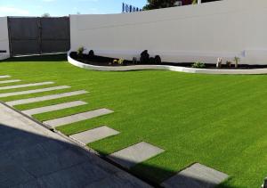 Un campo verde de hierba al lado de un edificio en LUXURY DUPLEX ATLANTIC FOUR SEASONS, en Santa Cruz de Tenerife