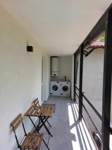 a balcony with two chairs and a washing machine at Elegant Tuscany Mountain Villa in Momigno