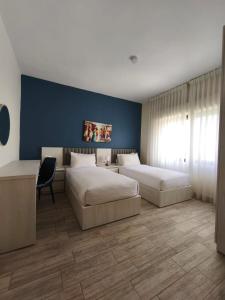 a bedroom with two beds and a blue wall at 46 Serviced Apartments in Amman