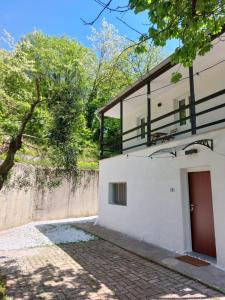 a white building with a red door and a fence at Elegant Tuscany Mountain Villa in Momigno +34 photos