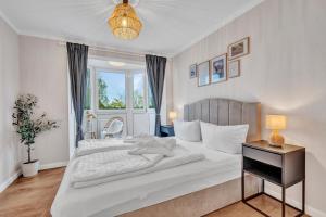 a bedroom with a large white bed and a table at Dein Ruhepol an der Nordseeküste mit Sauna in Cappel-Neufeld