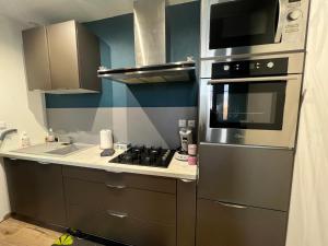 a kitchen with a stove and a microwave at F2 chez Cathy et Mike wittenheim in Wittenheim