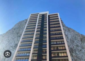 a tall building in front of a mountain at New CP Luxury studio with spa in Gibraltar