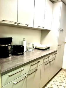 a kitchen with white cabinets and a counter top at PREMIUM HOME in Busingen am Hochrhein