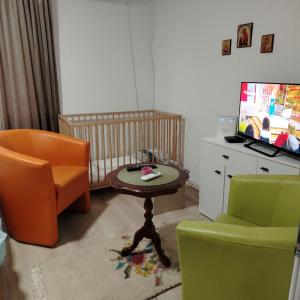 a living room with a crib and a table and chairs at Vila Raj in Gornja Toplica +34 photos
