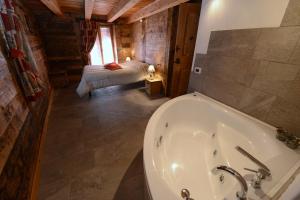 een badkamer met een bad en een slaapkamer bij Vieilles Maisons D'Introd in Introd