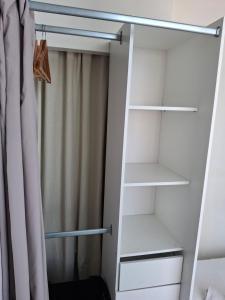 un armario con estanterías blancas y una cortina en Appartement lumineux dans les hauts de Recouvrance, en Brest