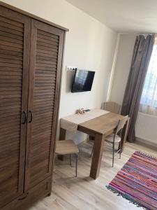 a room with a wooden table and a wooden cabinet at RELAX PENZIÓN J&L in Pavčina Lehota