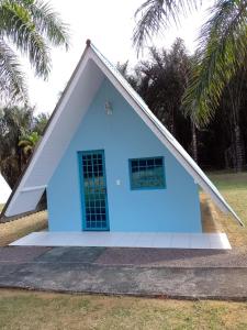 a small blue house with a white roof at Pousada Alpes Presidente Figueiredo in Presidente Figueiredo