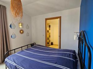 a bedroom with a bed with a blue comforter at Au contact de la nature in Chatuzange-le-Goubet