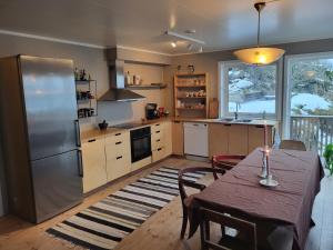 a kitchen with a table and a refrigerator at Private Apartment By The Sea in Vestvågøya