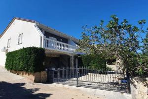 a white house with a wrought iron fence at Charming Apartment in Pag with Sea View, 40 sqm in Pag