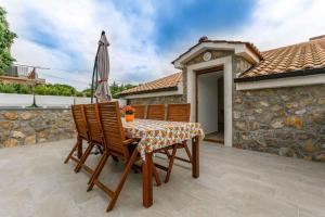 ein Tisch und Stühle mit einem Sonnenschirm auf einer Terrasse in der Unterkunft Apartment in Malinska - Insel Krk 38057 in Malinska