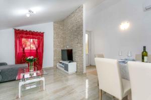 ein Wohnzimmer mit einer Couch und einem Tisch und einem Fernseher in der Unterkunft Apartment in Malinska - Insel Krk 38057 in Malinska