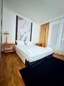 a bedroom with a large bed and a large window at Hotel Consul in Sofia