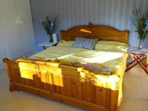 a wooden bed with a wooden frame in a bedroom at Humlehjarta Schweden Norrbotten Ferienhaus Ferienwohnung in Överkalix +55 photos