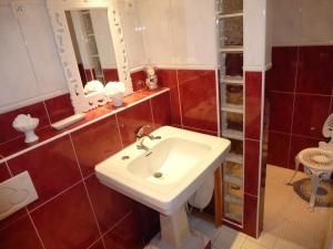 a bathroom with a white sink and red tiles at G2 Fully equipped apartment 1 à 4 pers 3 stars WiFi in Le Tholy