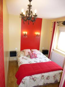 a bedroom with a bed with a red wall at G2 Fully equipped apartment 1 à 4 pers 3 stars WiFi in Le Tholy