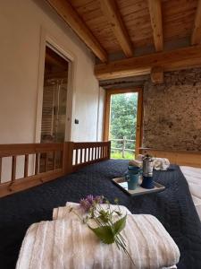a bedroom with a bed and a table with flowers on it at Chalet il Nocciolo in Avenone