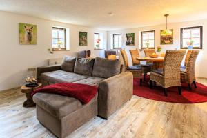 a living room with a couch and a table at Ferienhaus Sissi - Wellness-Paradies in ruhiger Lage mit Whirlpool und Sauna in Großschönau