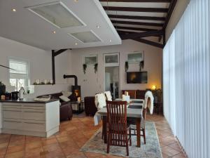 a kitchen and living room with a table and chairs at Gemütliches Loft mit Terrasse im ehemaligen Bahnhof Kalenborn in Vettelschoß