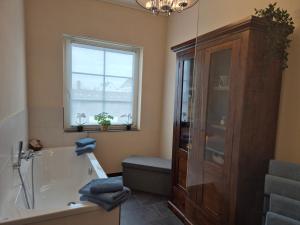 a bathroom with a bath tub and a window at Gemütliches Loft mit Terrasse im ehemaligen Bahnhof Kalenborn in Vettelschoß +32 photos