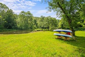 two surfboards on a picnic table next to a river at WaterFront Cabin Hot Tub Kayaks Firepit Game Consoles in Tunkhannock