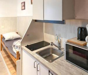 a small kitchen with a sink and a bed at Studio cosy à Uvernet-Fours / 15 m² / Vue montagne in Uvernet-Fours +6 photos