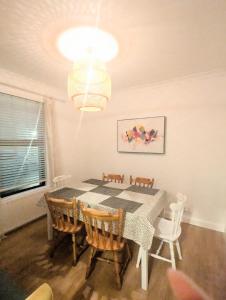 a dining room with a table and chairs and a chandelier at Ivy Townhouse Derry in Derry Londonderry