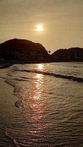 a sunset on a beach with the sun setting at Departamentos Cerro Azul P2 in Cerro Azul