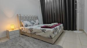 a bedroom with a bed and a night stand with a lamp at Cozy 2-bedroom apartment near KLIA, Putrajaya & Cyberjaya in Sepang +15 photos