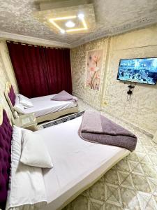 a hotel room with two beds and a flat screen tv at Sporting star in Alexandria