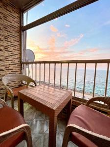 a balcony with a table and chairs and a view of the ocean at Sporting star in Alexandria