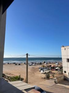 a view of a beach with cars and the ocean at Line Up Surf House in Agadir