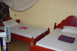 two beds in a small room withskirts at Safari Junction Backpackers Hostel Mwanza in Mwanza +31 photos