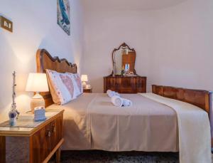 a bedroom with a bed with two rolled towels on it at Villetta Tramontana 30 Metri Dalla Spiaggia in Torre Specchia Ruggeri