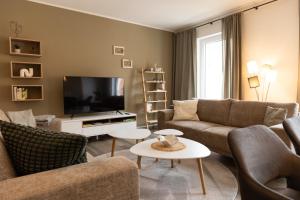 a living room with two couches and a flat screen tv at MARKINA: Penthaus - Burgblick in Treffurt