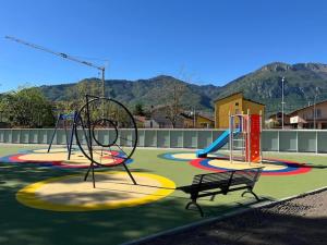 a playground with two slides and a bench in a park at Appartamento Rita in Pisogne