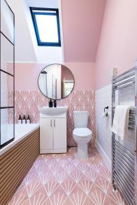 Un baño con lavabo, inodoro y espejo. en Taigh Carnan, en Inverness